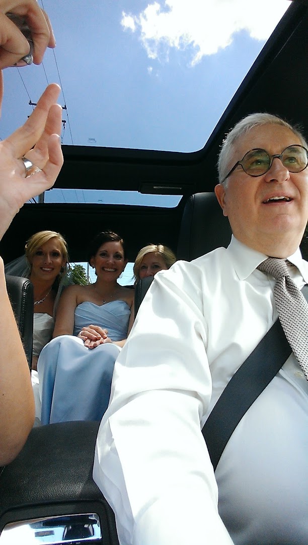 Driver and wedding party passengers inside a luxury vehicle with panoramic sunroof